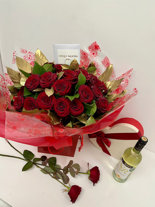 24 Luxurious, most elegant Naomi Red Rose, with Gold Fatsia Leaf and long stem salad. Wrapped in acoordinating cellophane as a special gift Bouquet. 